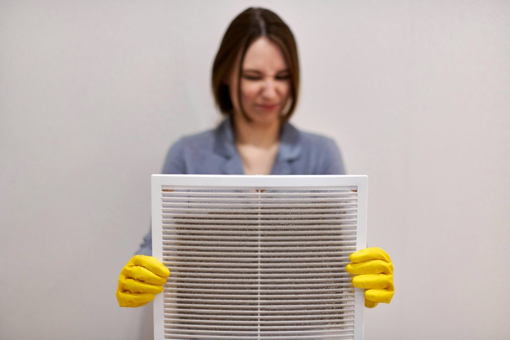 Woman holds dirt ac air filter