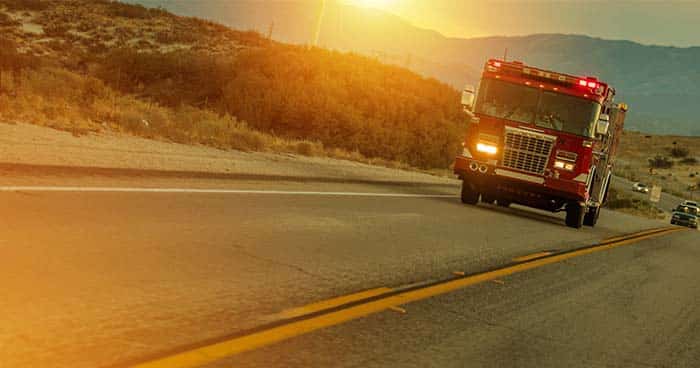 A firetruck barrels down the highway on the way to a fire.