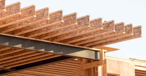 Image: house under construction with exposed joists.