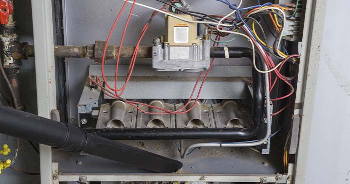 Image: inside a furnace getting vacuumed out.